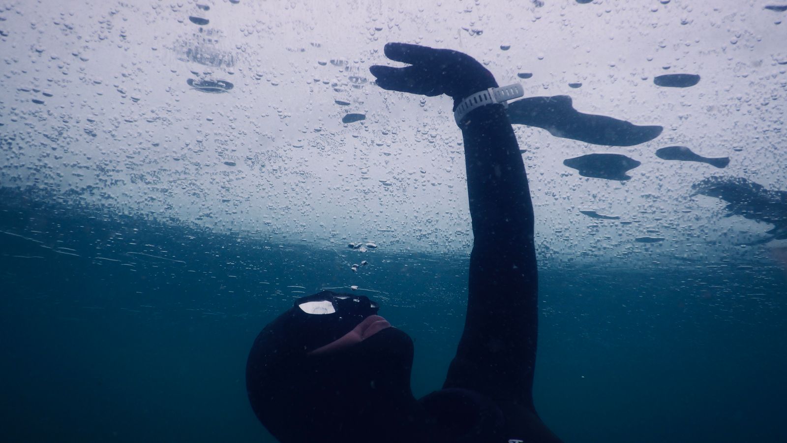 Freediver wearing a conventional mask beneath a sheet of ice